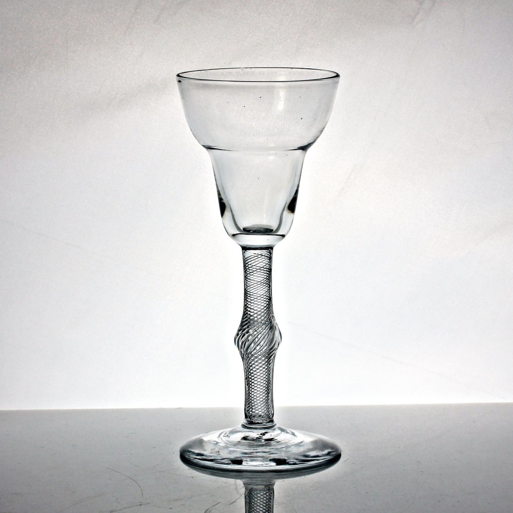 A hand-blown Georgian lead glass goblet featuring a pan-top bowl, a multi-spiral air twist stem with a central knop, and a wide conical foot.