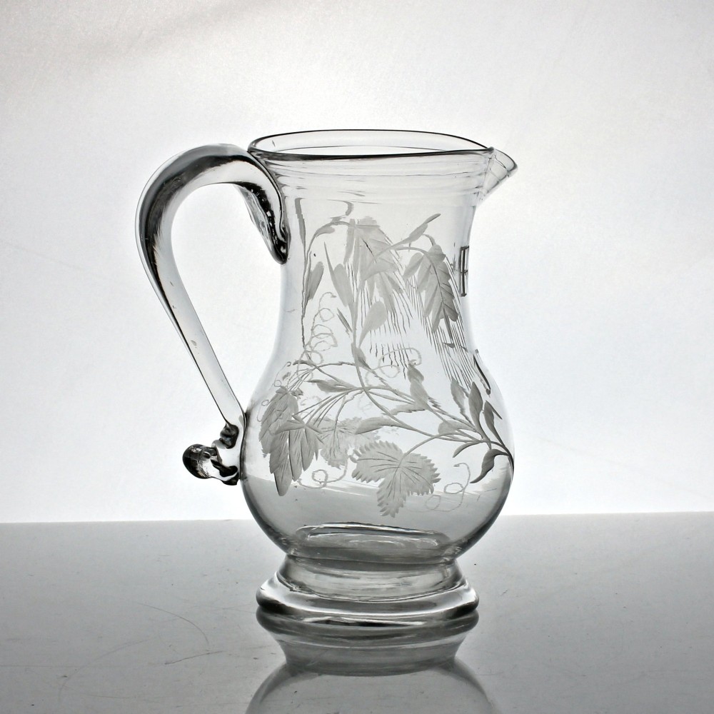 A clear glass Georgian jug decorated with wheel-engraved hop and barley motifs and fitted with an applied loop handle. View III