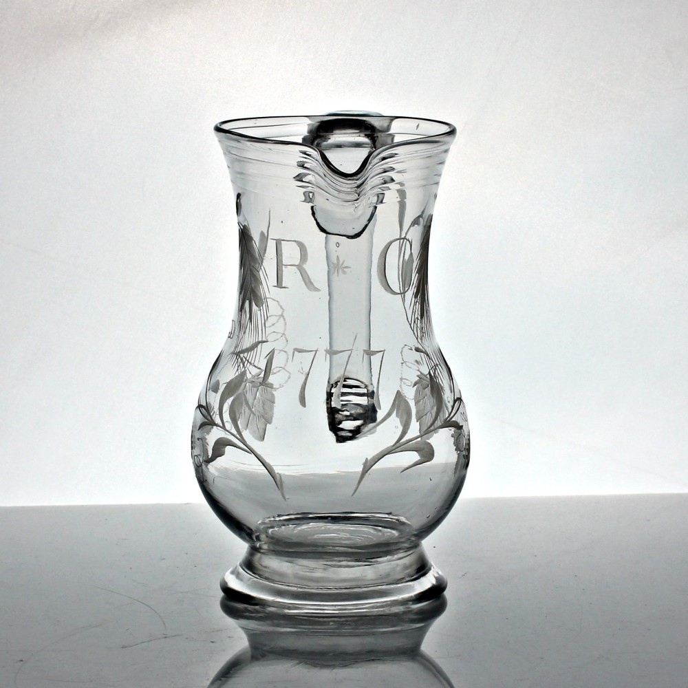 A clear glass Georgian jug decorated with wheel-engraved hop and barley motifs and fitted with an applied loop handle. View IV