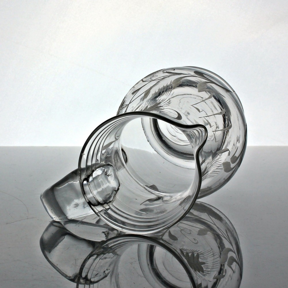 A clear glass Georgian jug decorated with wheel-engraved hop and barley motifs and fitted with an applied loop handle. View V