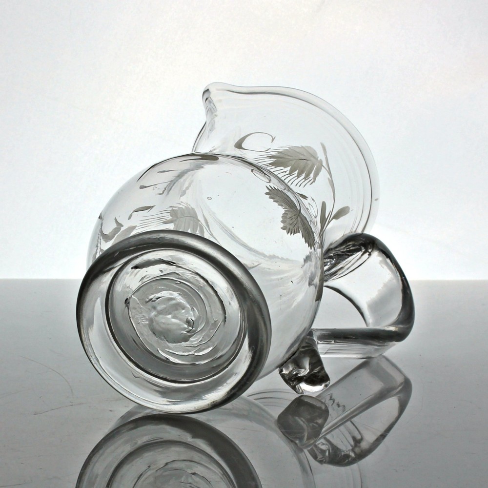 A clear glass Georgian jug decorated with wheel-engraved hop and barley motifs and fitted with an applied loop handle. View VI