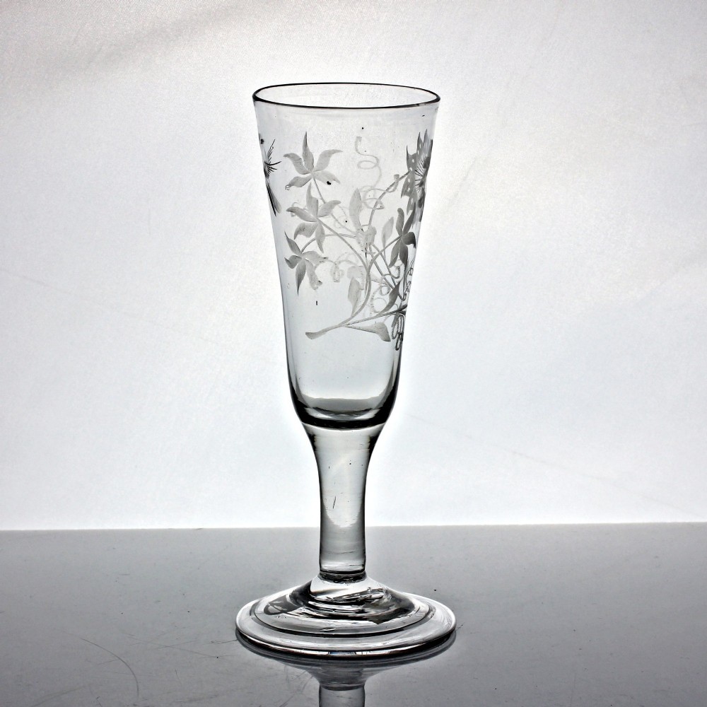 A Georgian clear lead glass ale flute featuring a plain stem, a folded foot, and a wheel-engraved passion flower motif on the bowl. View II