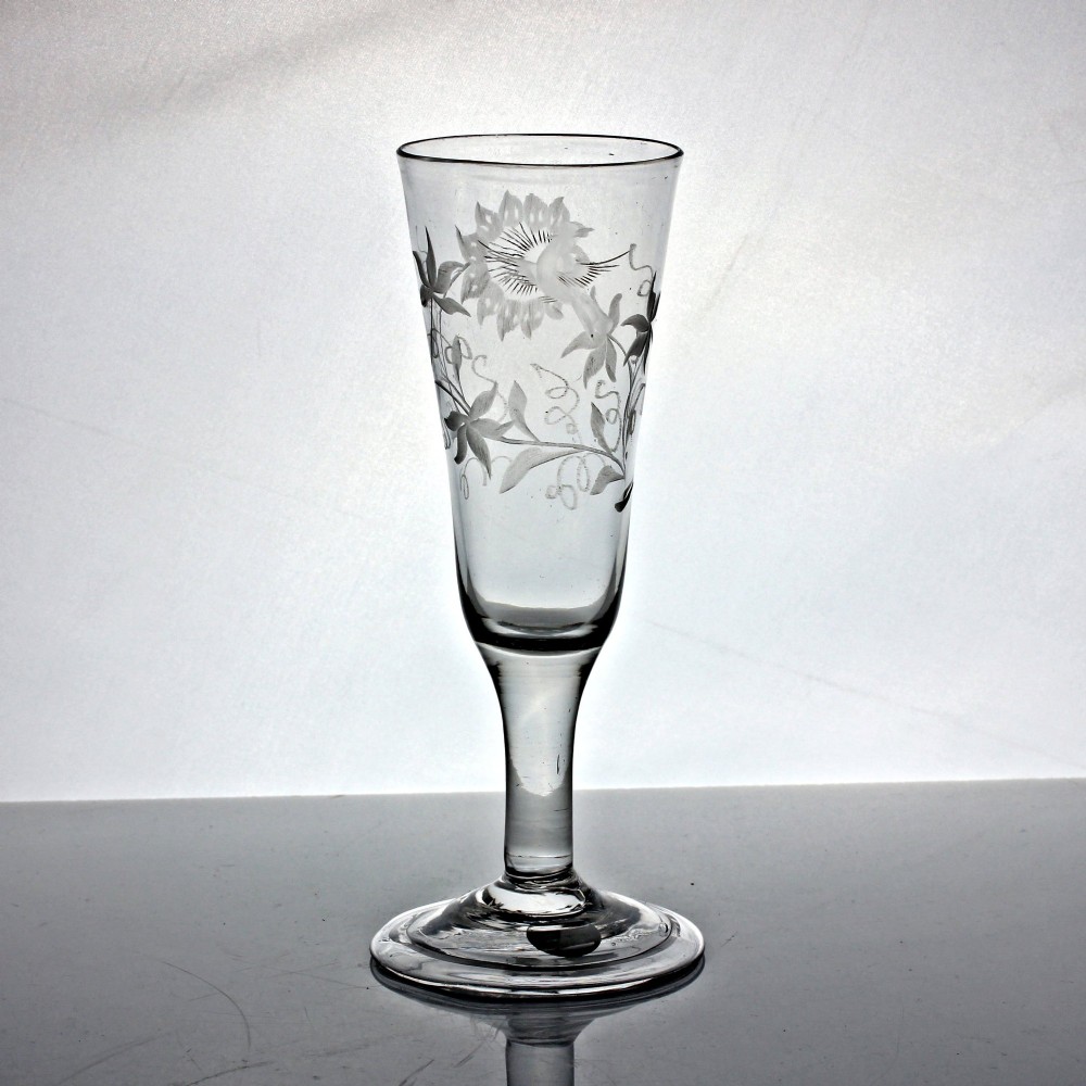 A Georgian clear lead glass ale flute featuring a plain stem, a folded foot, and a wheel-engraved passion flower motif on the bowl. View III