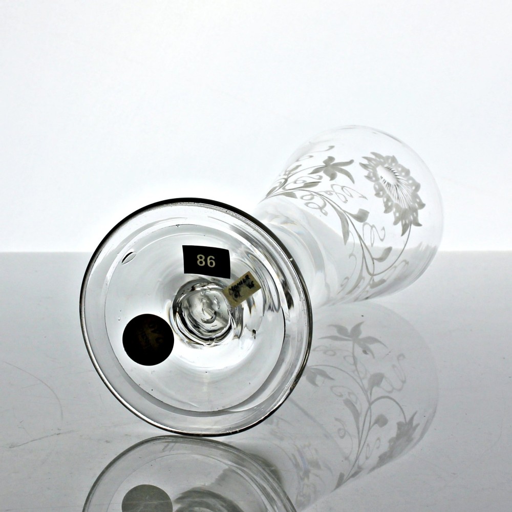 A Georgian clear lead glass ale flute featuring a plain stem, a folded foot, and a wheel-engraved passion flower motif on the bowl. View VI