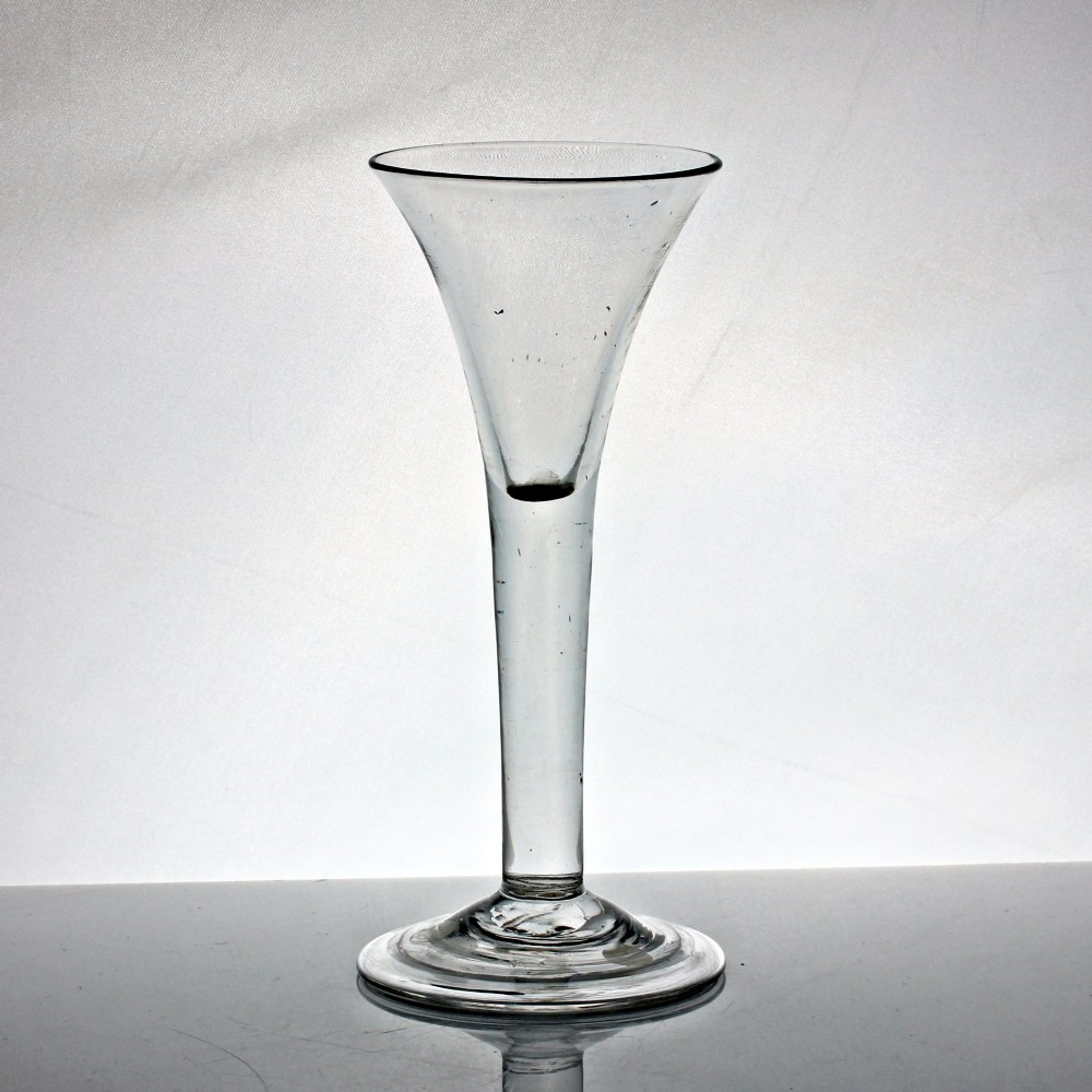 A clear Georgian glass wine goblet featuring a tall trumpet bowl, a solid plain stem, and a wide folded conical foot.