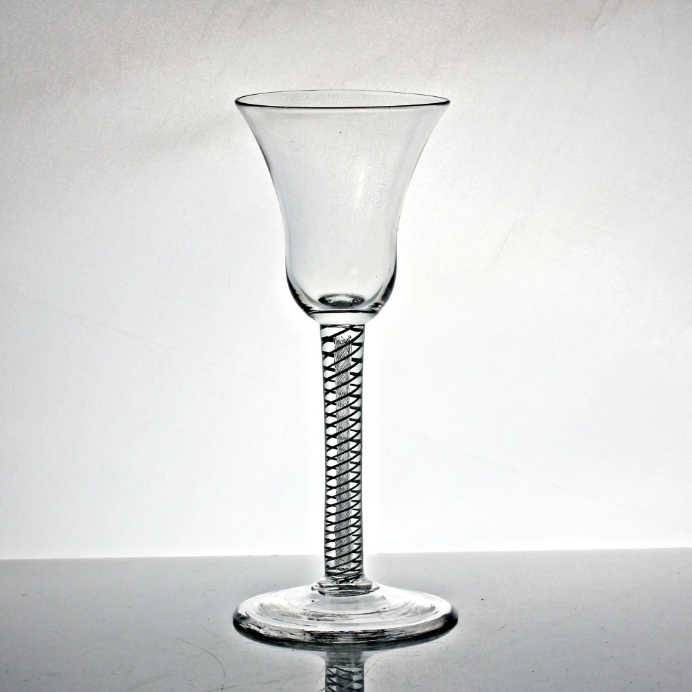 A clear Georgian glass goblet featuring a flared bell bowl resting on a tall mixed-twist stem and circular base. View II