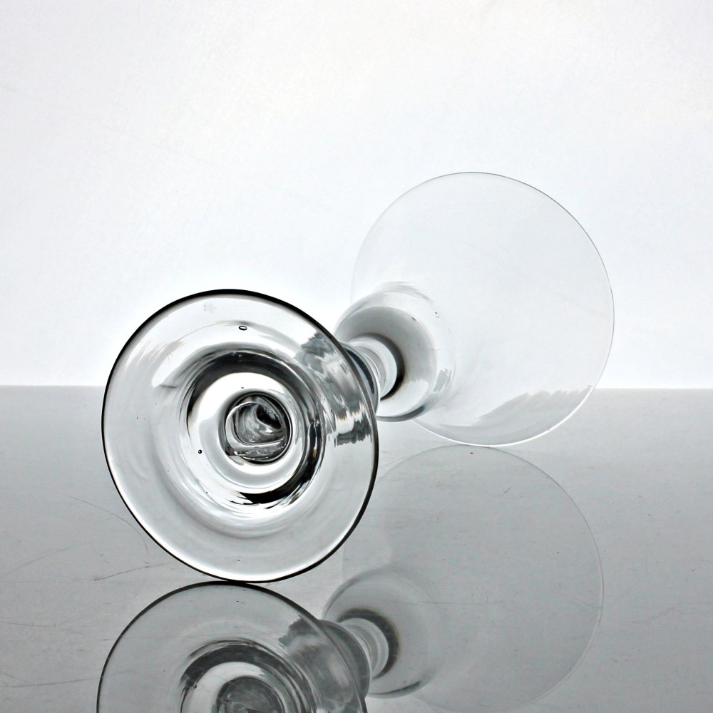 An 18th-century clear glass wine glass featuring a flared bell-shaped bowl, a turned baluster stem with knops, and a wide domed foot. View III