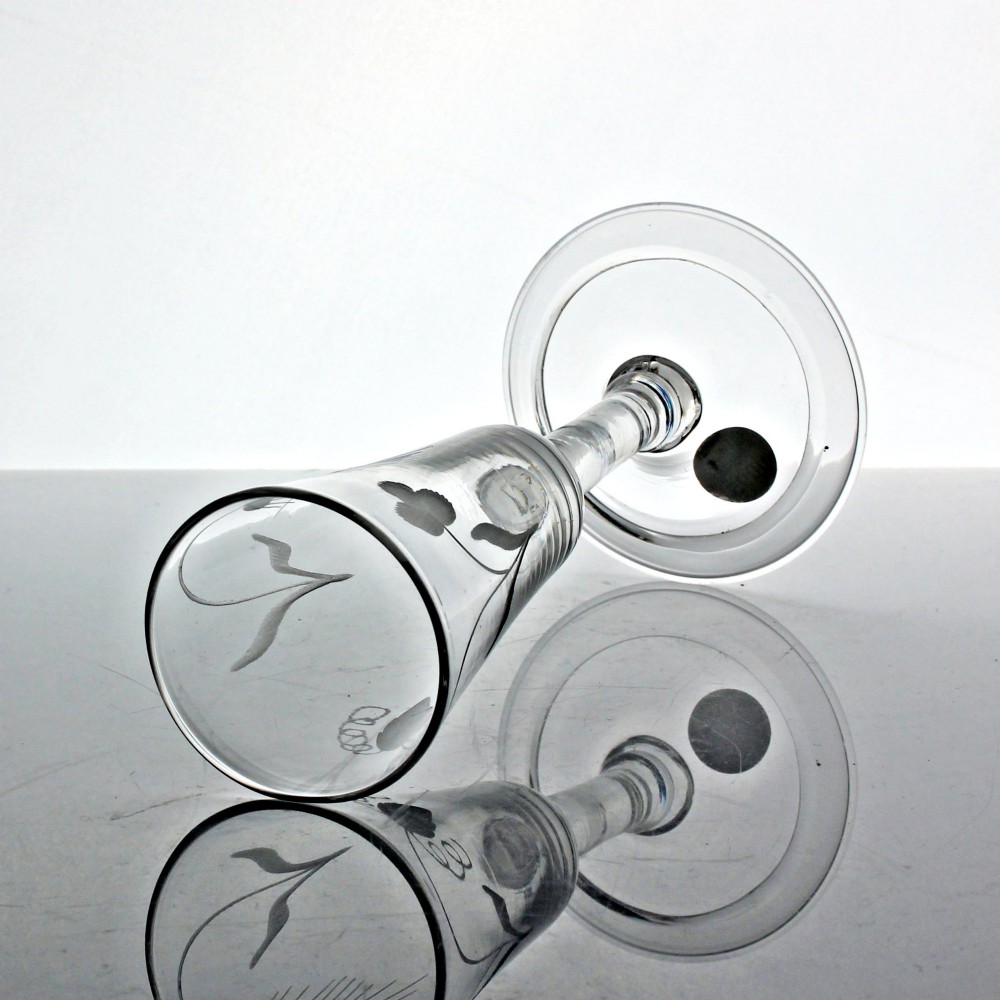 An antique clear glass ale flute featuring wheel-engraved hop and barley motifs on a tall bowl supported by a balustroid stem and folded foot. View III