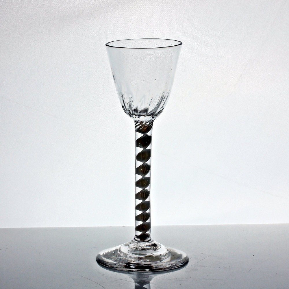 An 18th-century Georgian clear glass wine glass featuring a single series opaque twist stem, a rounded funnel bowl with fluted base, and a conical foot. View II