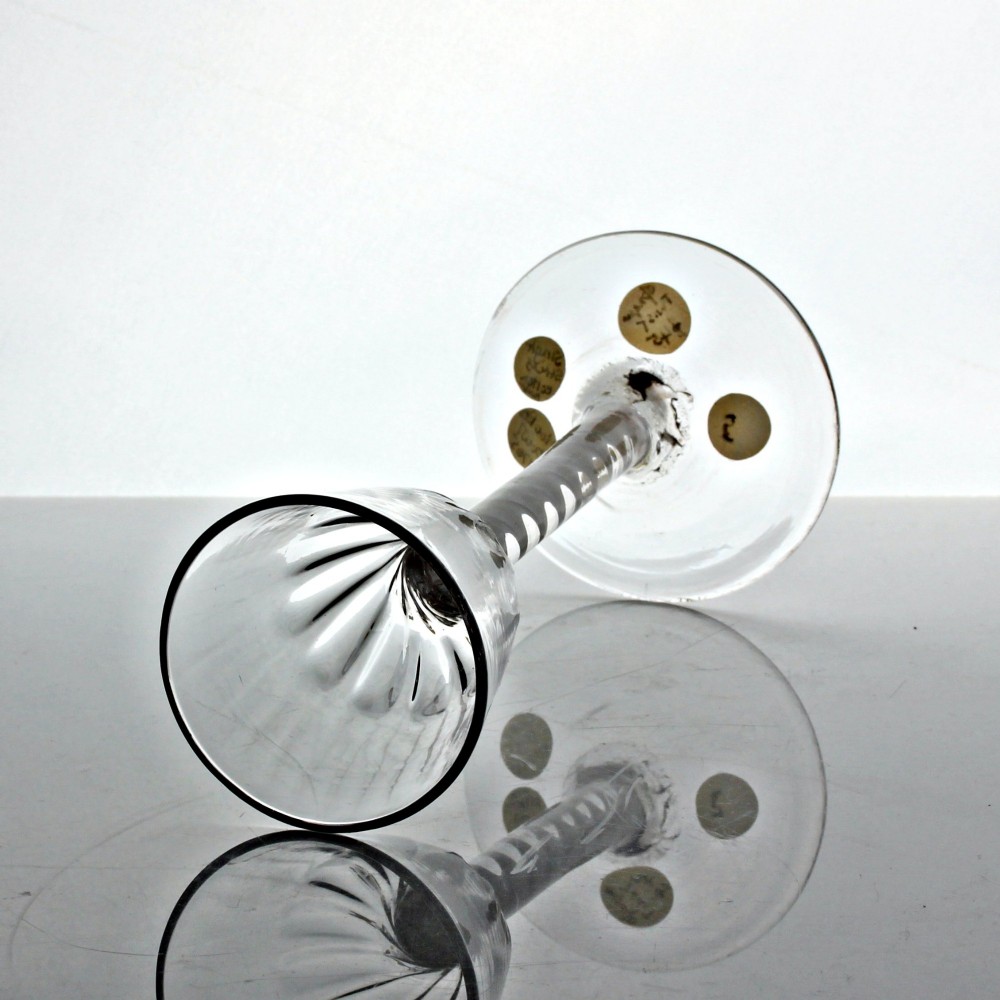 An 18th-century Georgian clear glass wine glass featuring a single series opaque twist stem, a rounded funnel bowl with fluted base, and a conical foot. View III
