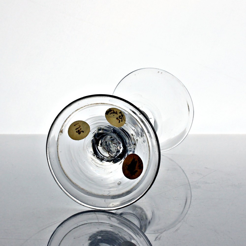 A clear hand-blown Georgian drinking glass featuring a flared bell bowl, a balustroid stem with knops, and a folded conical foot. View III