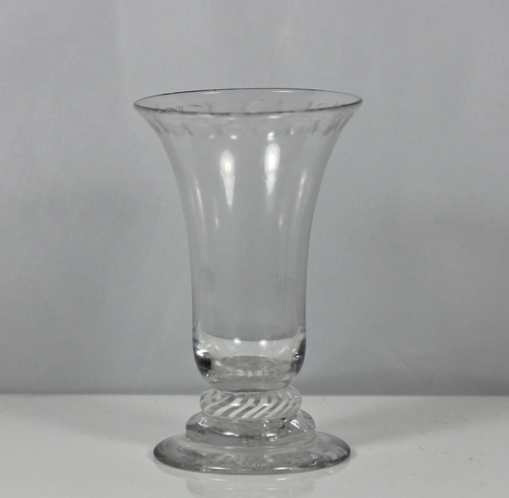 A Georgian clear glass jelly vessel featuring a flared rim, faint engraved detailing, and a short knopped stem with an embedded white opaque twist set above a circular foot.
