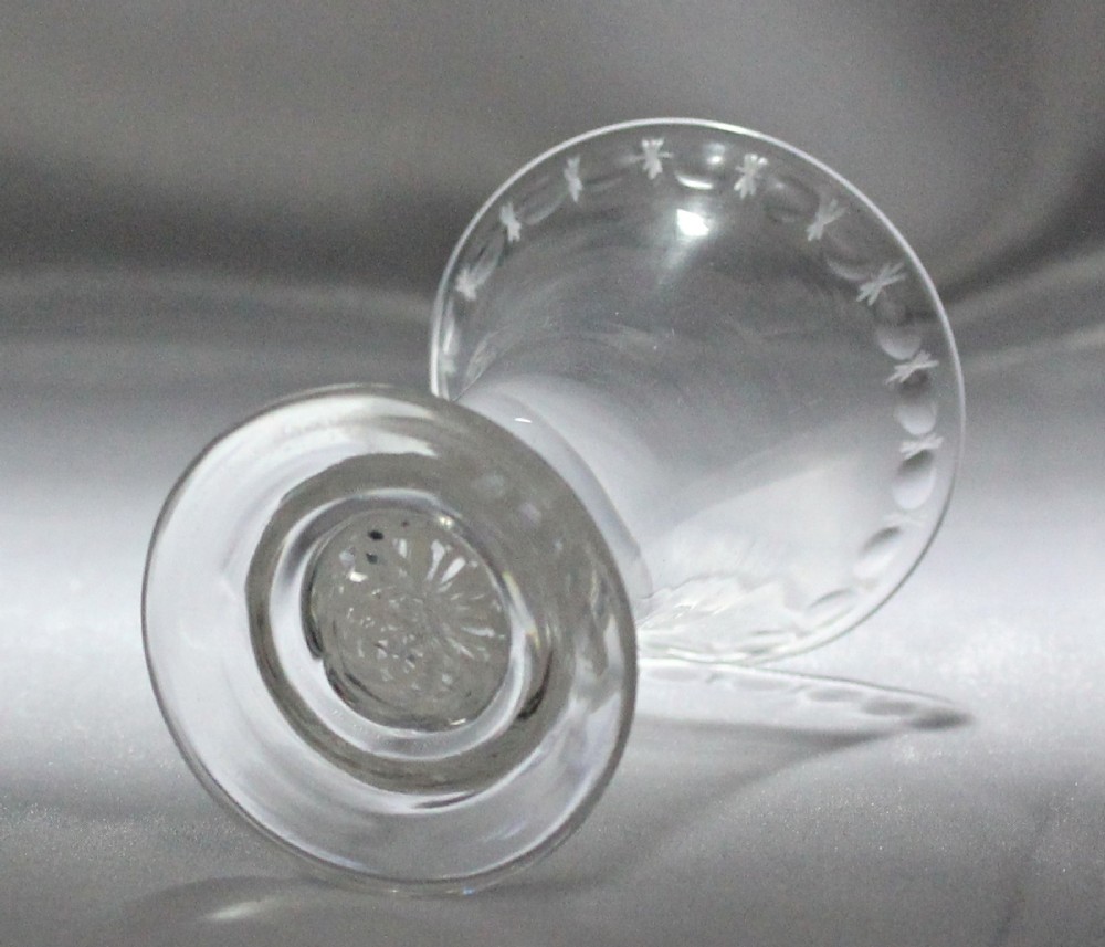 A Georgian clear glass jelly vessel featuring a flared rim, faint engraved detailing, and a short knopped stem with an embedded white opaque twist set above a circular foot. View II