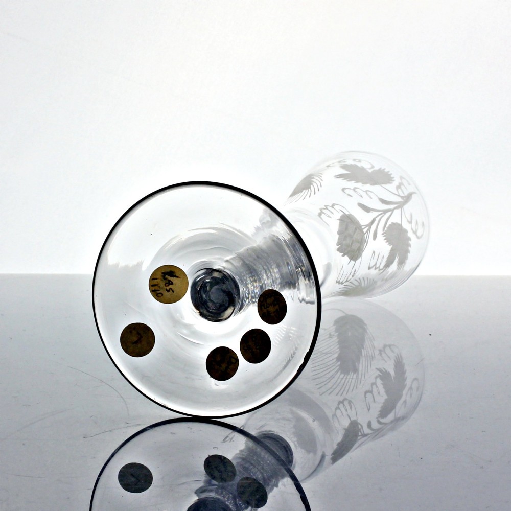 An antique clear glass ale flute featuring a double series opaque twist stem and an engraved hop and barley motif on the bowl. View V