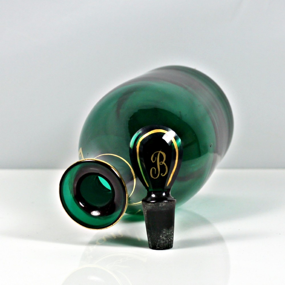 A set of three Georgian Bristol green glass decanters with gilded labels for Brandy, Hollands, and Rum, featuring monograms on the disc stoppers. View III