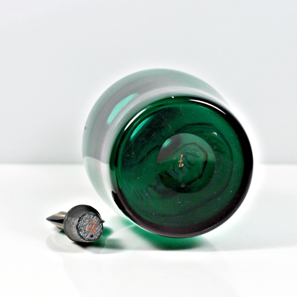 A set of three Georgian Bristol green glass decanters with gilded labels for Brandy, Hollands, and Rum, featuring monograms on the disc stoppers. View IV