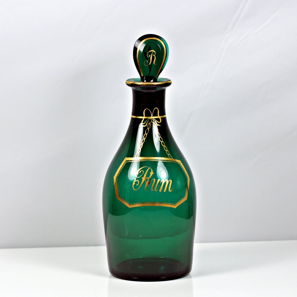 A set of three Georgian Bristol green glass decanters with gilded labels for Brandy, Hollands, and Rum, featuring monograms on the disc stoppers. View VIII
