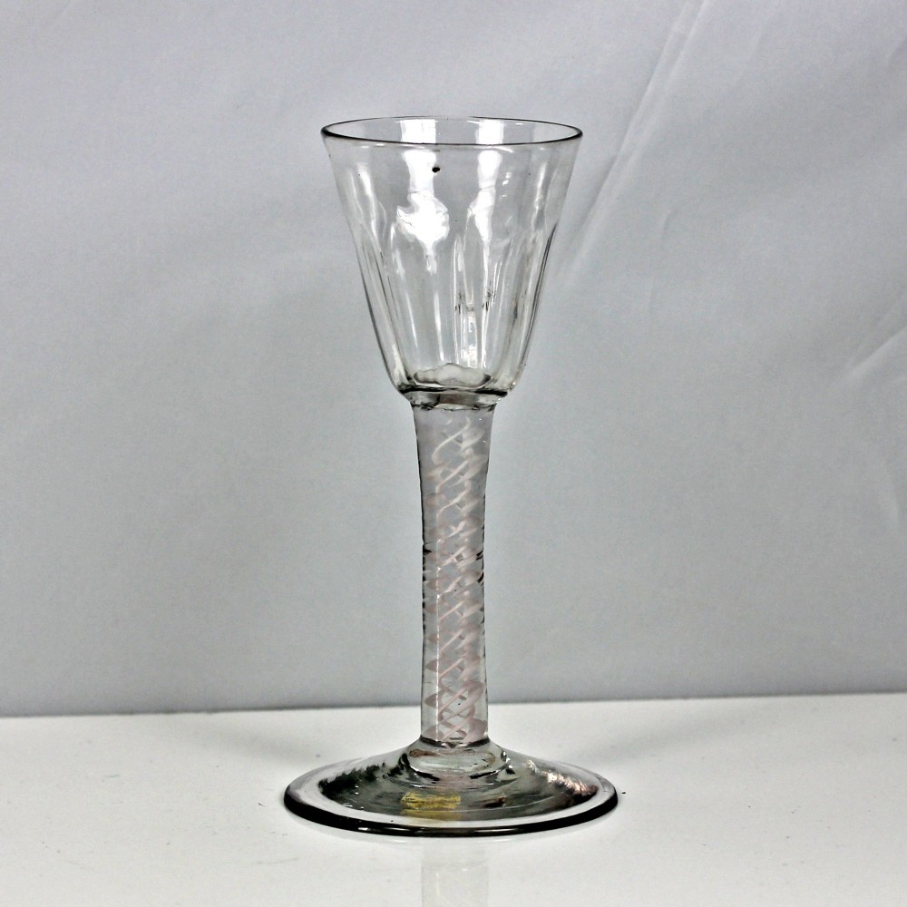 A Georgian clear glass wine glass featuring a flute-moulded rounded funnel bowl, a double series opaque twist stem, and a flat conical foot.
