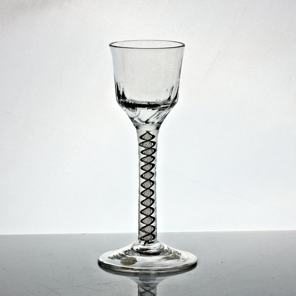 A clear Georgian wine glass featuring a wrythen moulded bowl resting on a stem with an internal double series opaque twist pattern and a broad conical foot. View II