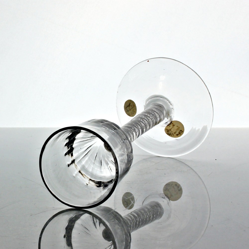 A clear Georgian wine glass featuring a wrythen moulded bowl resting on a stem with an internal double series opaque twist pattern and a broad conical foot. View III