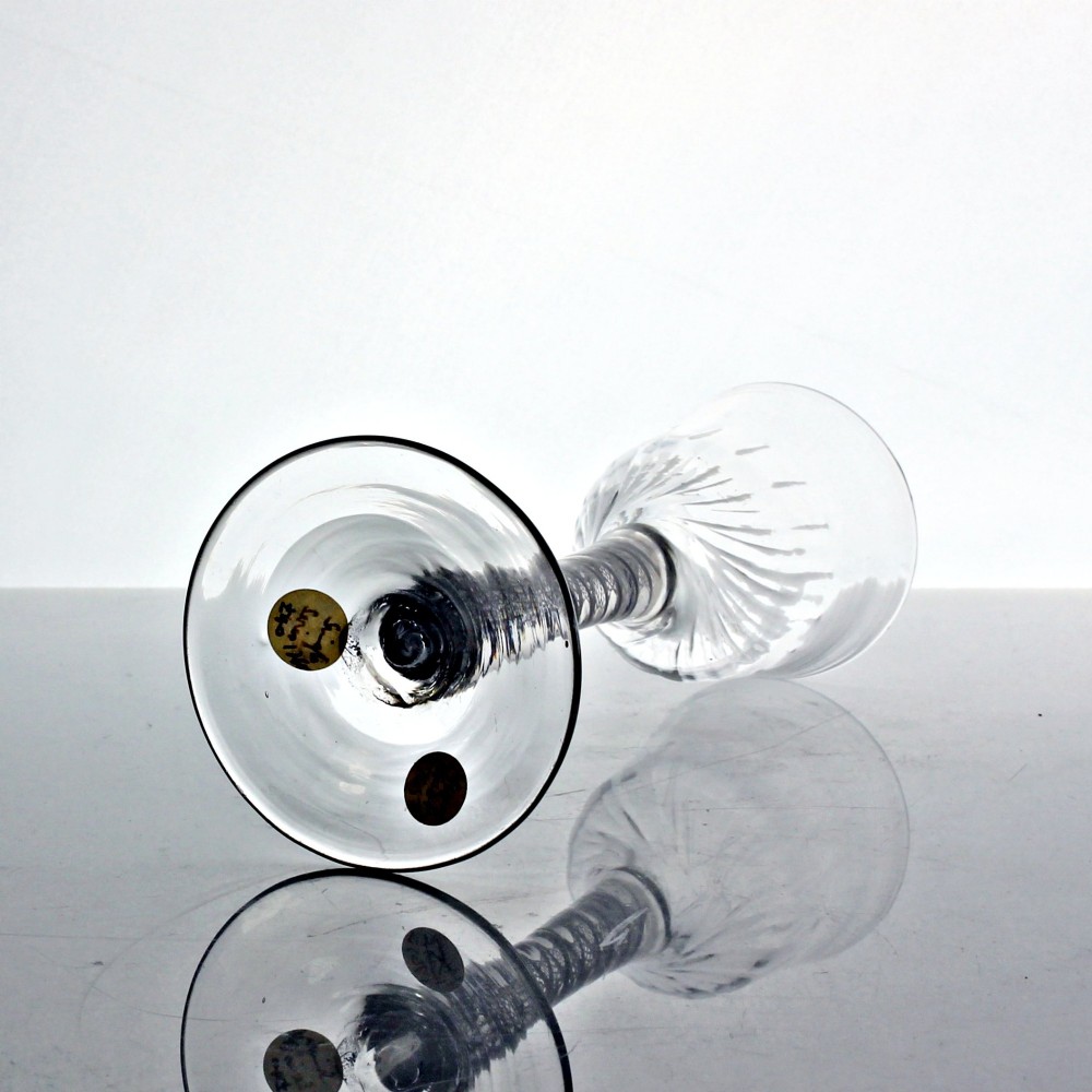 A clear Georgian wine glass featuring a wrythen moulded bowl resting on a stem with an internal double series opaque twist pattern and a broad conical foot. View IV