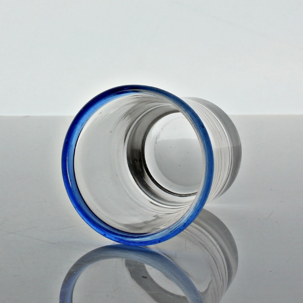 A small clear hand-blown glass tumbler featuring an applied cobalt blue glass rim around the top opening. View II