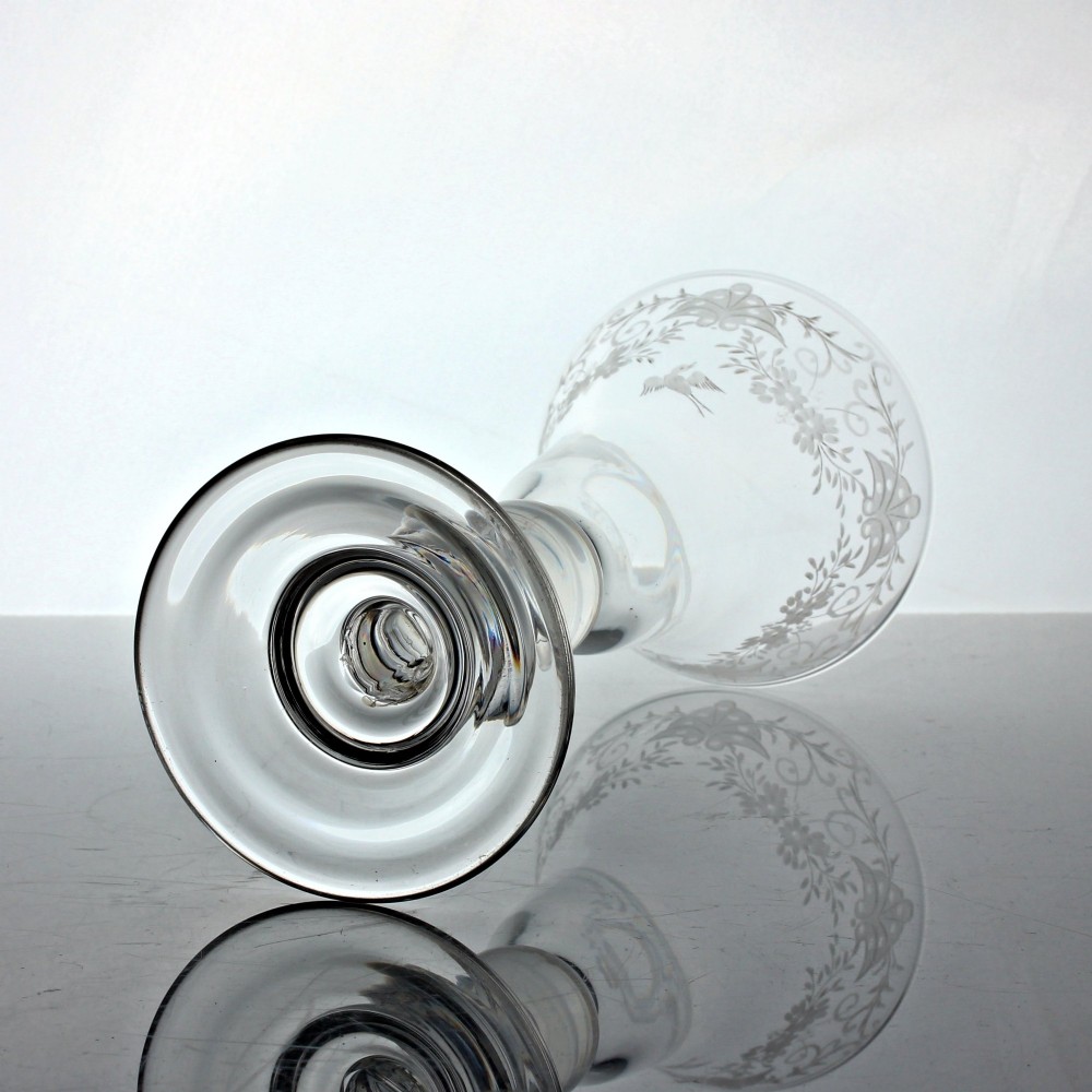 A clear Georgian lead glass goblet featuring a bell-shaped bowl with wheel-engraved floral and bird motifs, supported by a heavy baluster stem on a domed foot. View III