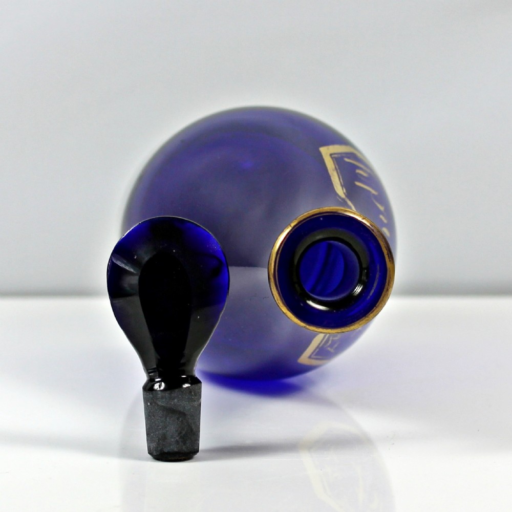 A Georgian cobalt blue glass brandy decanter featuring a tapered body with gilded lettering reading Brandy and a matching lozenge stopper. View II