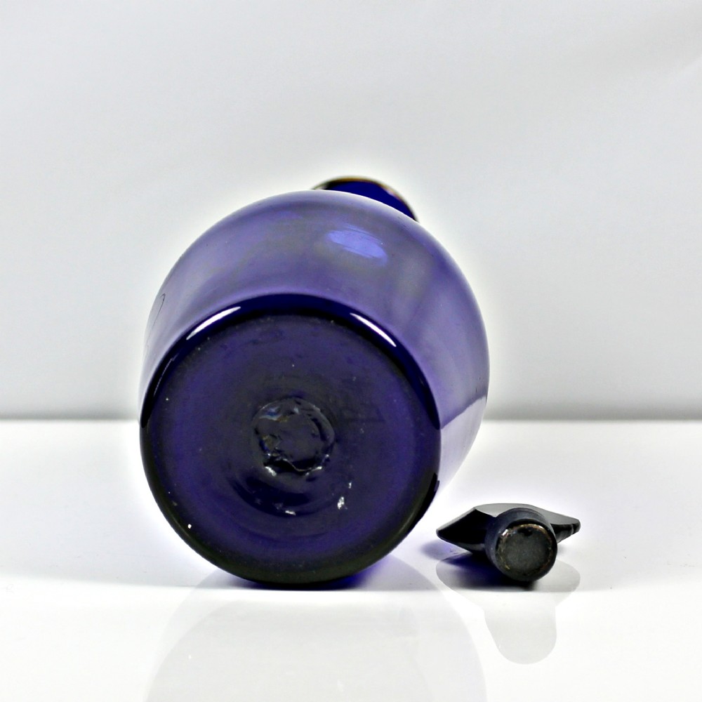 A Georgian cobalt blue glass brandy decanter featuring a tapered body with gilded lettering reading Brandy and a matching lozenge stopper. View III