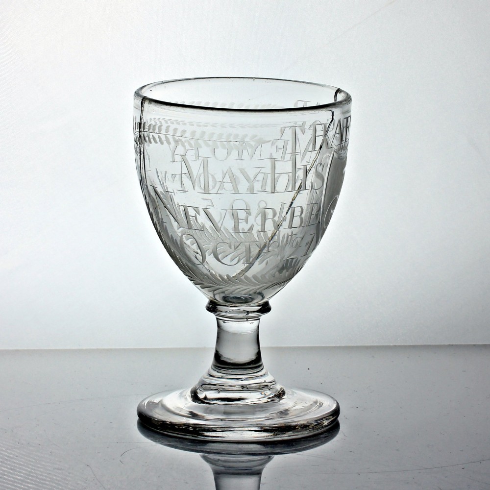 An antique clear glass rummer featuring hand-engraved naval motifs, text referencing Trafalgar, a short stem, and a circular foot. View IV