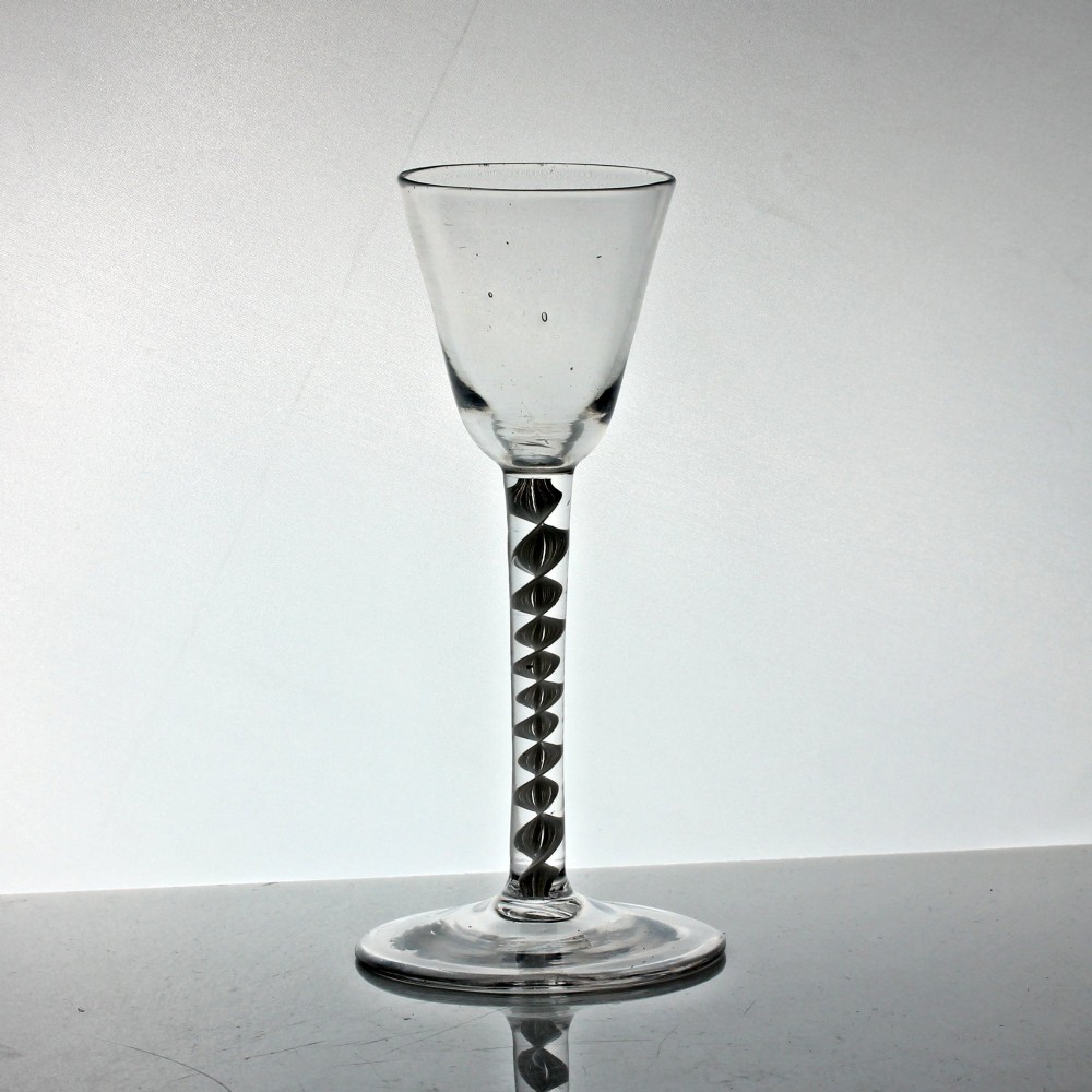 A clear Georgian glass featuring a tall bowl set atop a single series opaque twist stem and a wide circular foot.