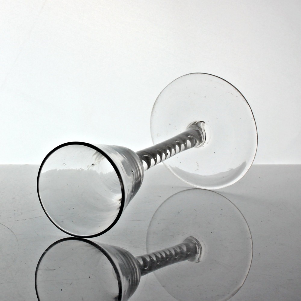 A clear Georgian glass featuring a tall bowl set atop a single series opaque twist stem and a wide circular foot. View II
