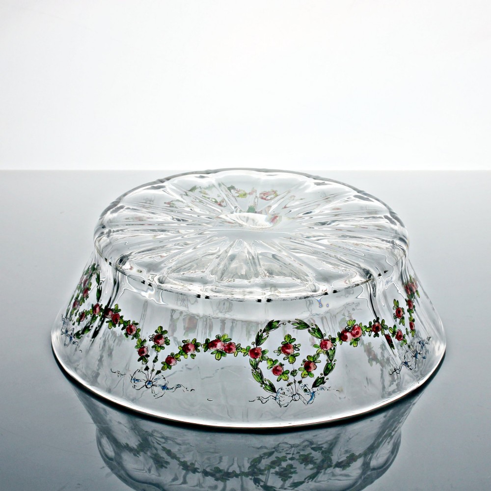 An oval clear glass bowl featuring hand-painted enamelled garlands of red roses, green foliage, and blue ribbons along the exterior with a gilded rim. View III