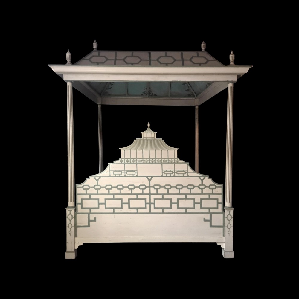 A cream-painted Edwardian four-poster bed frame featuring a pagoda-shaped headboard, decorative geometric fretwork, urn finials, and a painted canopy underside. View III