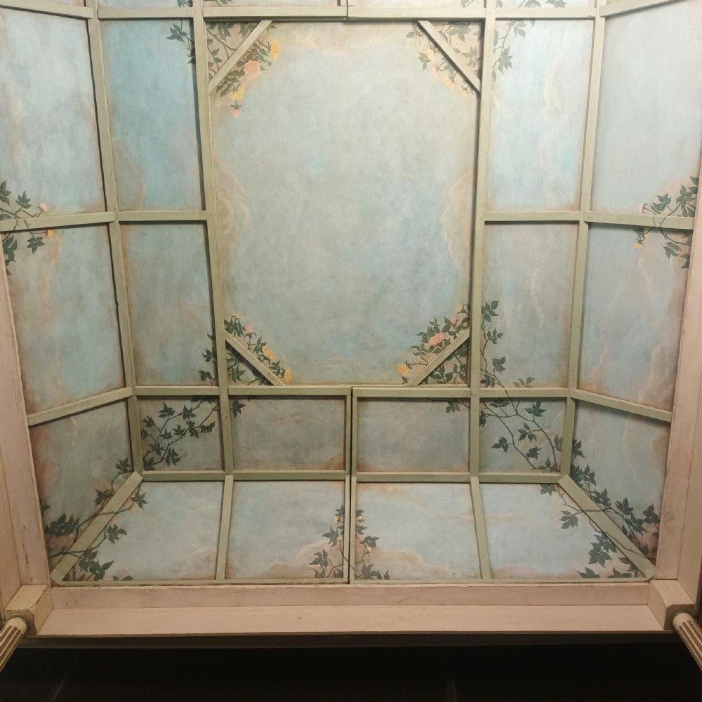 A cream-painted Edwardian four-poster bed frame featuring a pagoda-shaped headboard, decorative geometric fretwork, urn finials, and a painted canopy underside. View XXII