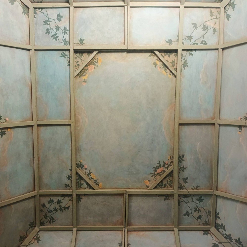 A cream-painted Edwardian four-poster bed frame featuring a pagoda-shaped headboard, decorative geometric fretwork, urn finials, and a painted canopy underside. View XXIII