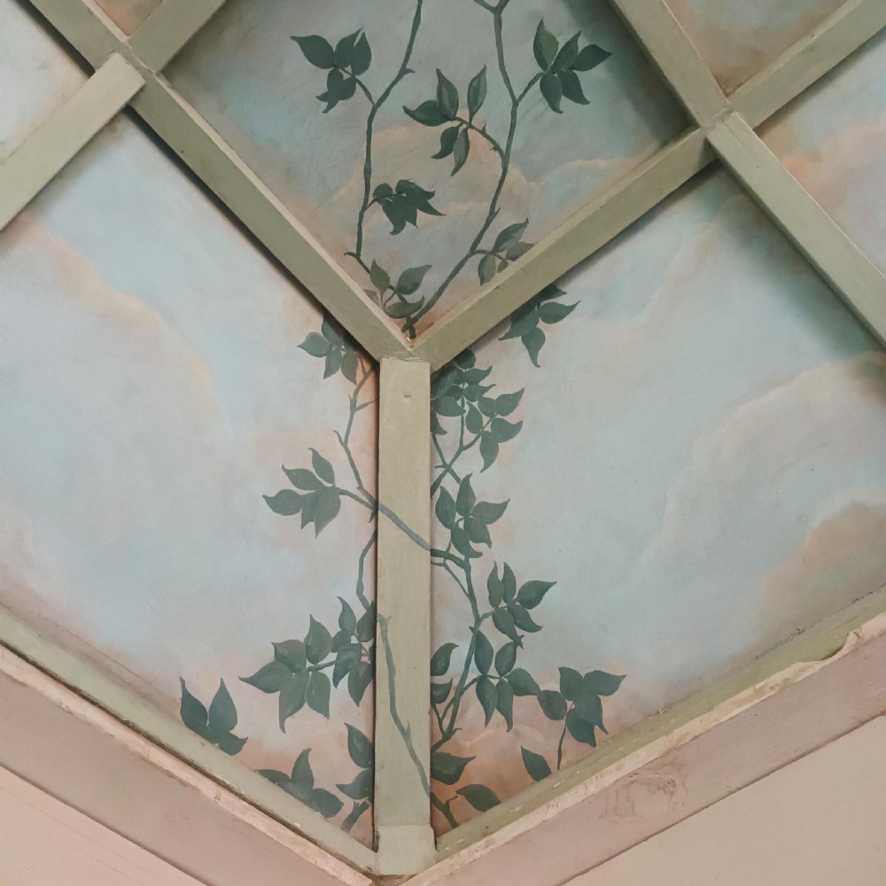 A cream-painted Edwardian four-poster bed frame featuring a pagoda-shaped headboard, decorative geometric fretwork, urn finials, and a painted canopy underside. View XXIV