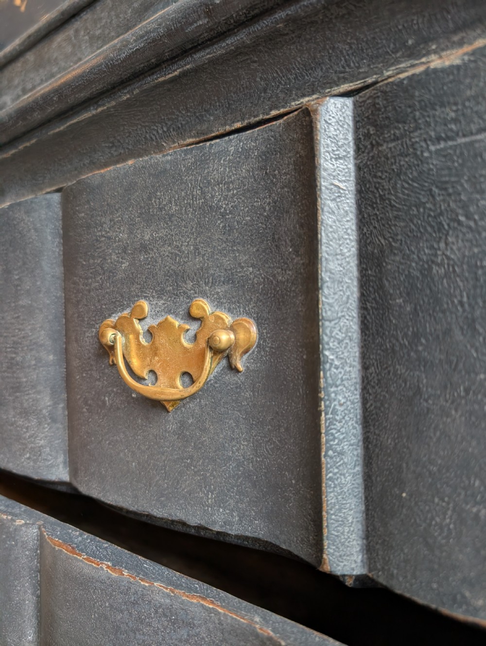 A tall dark grey painted Dutch vitrine cabinet featuring a shaped top hood, glazed upper doors, and three lower drawers with brass handles. View XII
