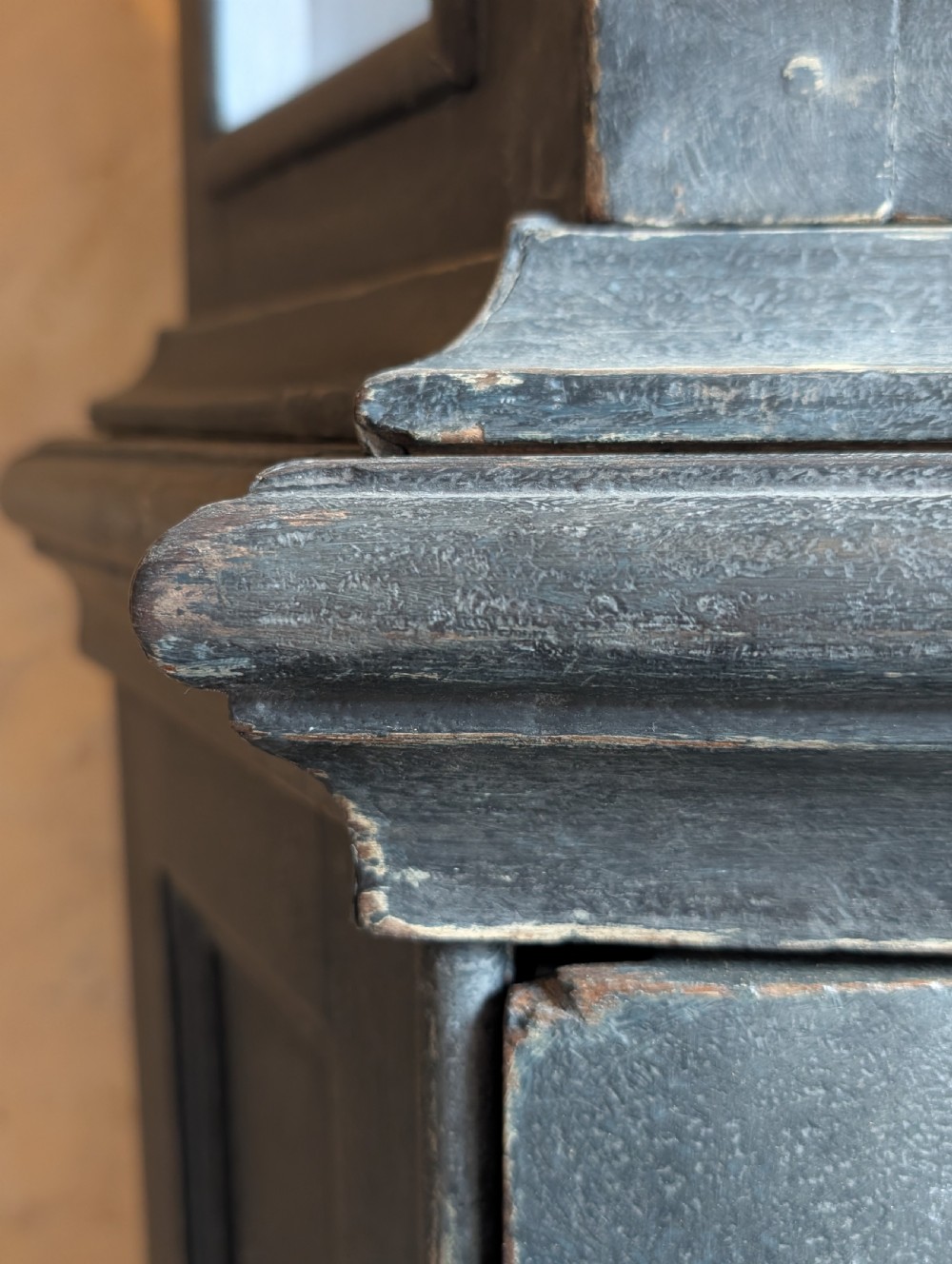 A tall dark grey painted Dutch vitrine cabinet featuring a shaped top hood, glazed upper doors, and three lower drawers with brass handles. View XV