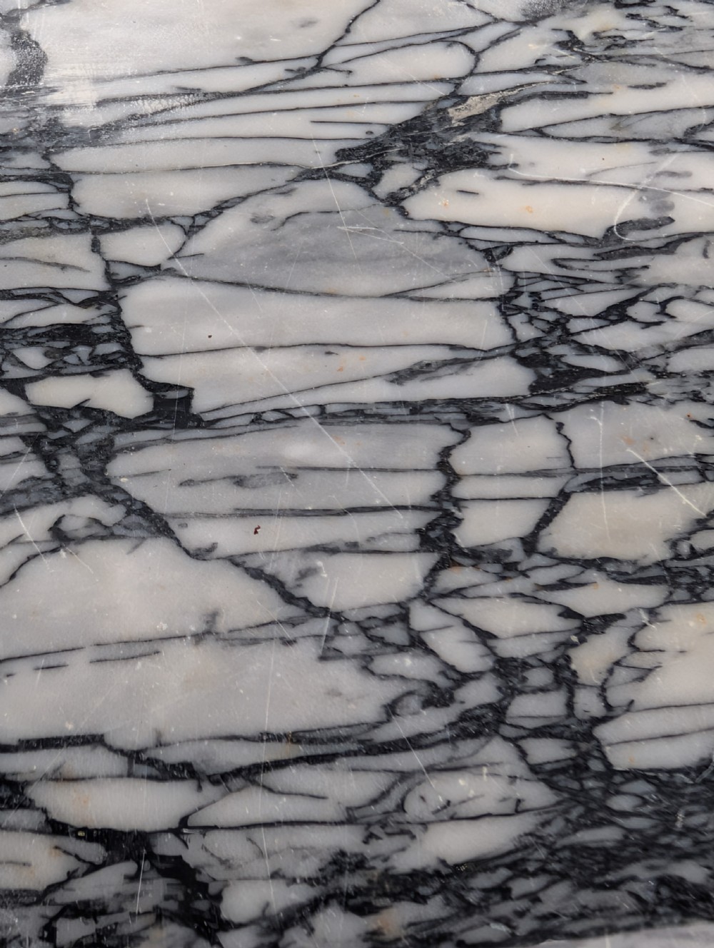 A rectangular grey veined marble top resting on a weathered cast iron base with twisted legs and scroll feet. View V