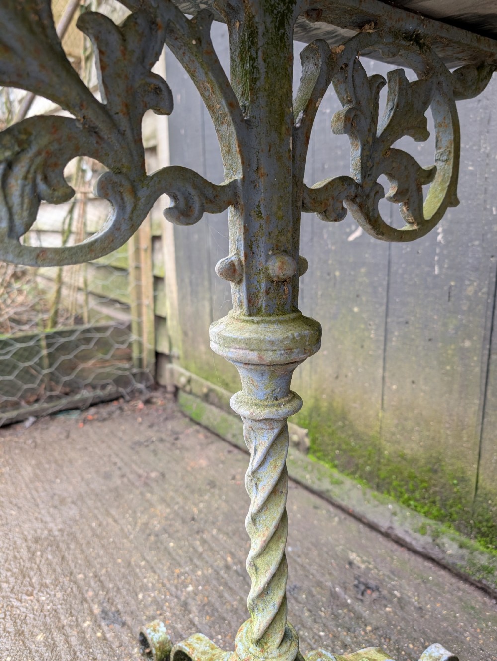 A rectangular grey veined marble top resting on a weathered cast iron base with twisted legs and scroll feet. View VI
