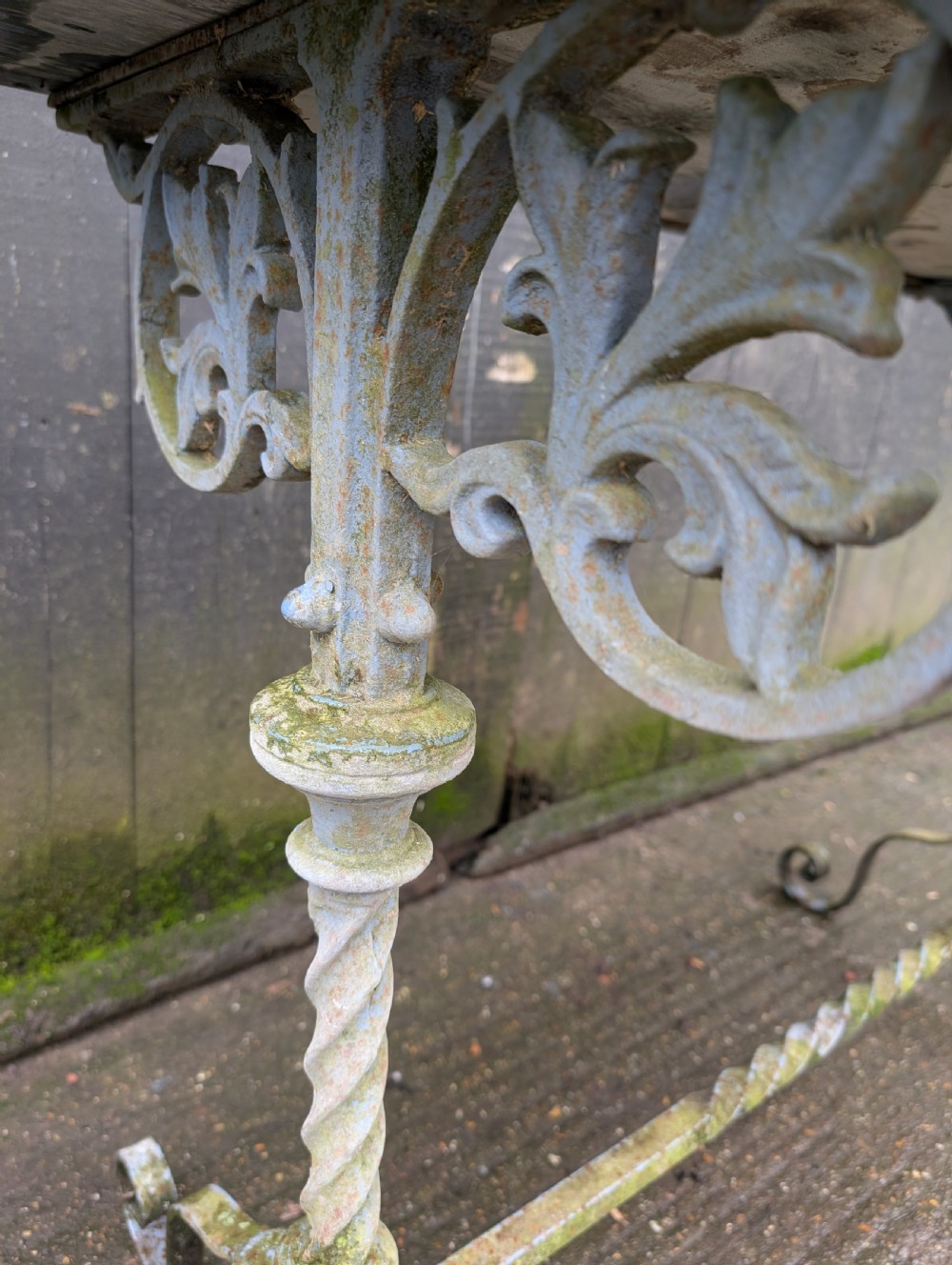 A rectangular grey veined marble top resting on a weathered cast iron base with twisted legs and scroll feet. View VIII