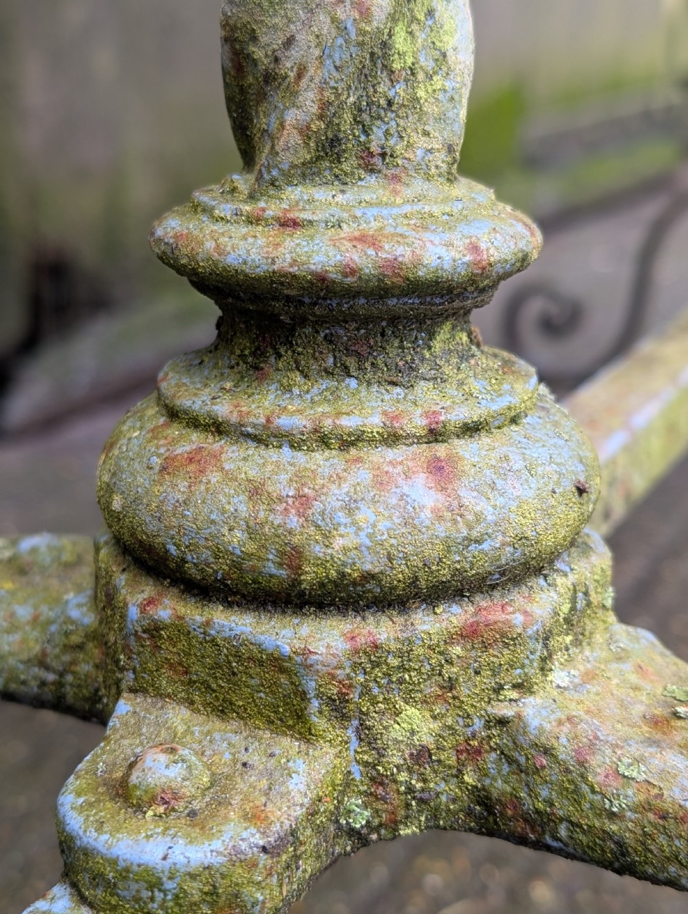 A rectangular grey veined marble top resting on a weathered cast iron base with twisted legs and scroll feet. View X