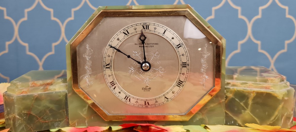 An Art Deco green onyx mantel clock with an octagonal brass-rimmed glass face featuring Roman numerals. View V
