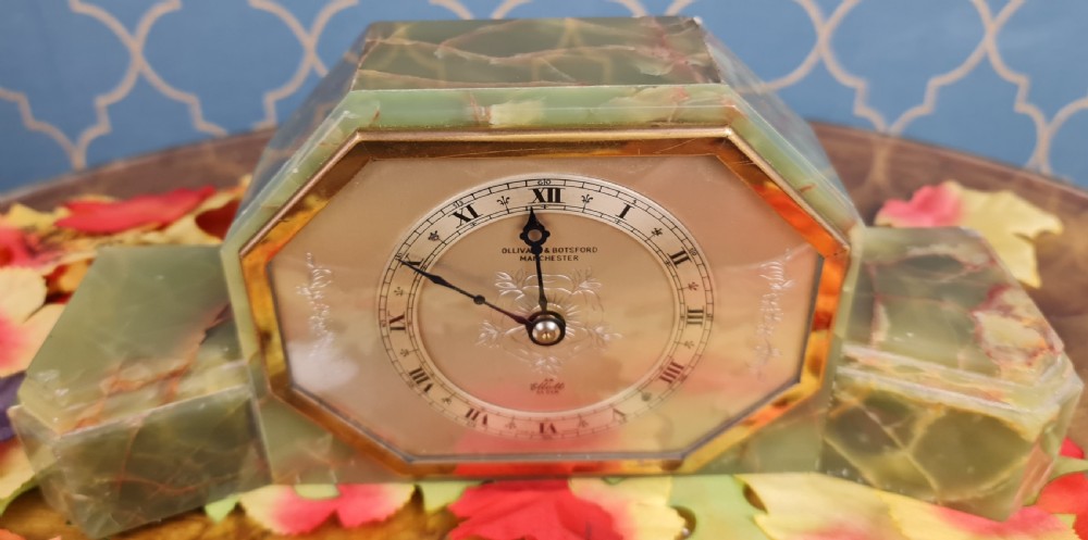 An Art Deco green onyx mantel clock with an octagonal brass-rimmed glass face featuring Roman numerals. View VI