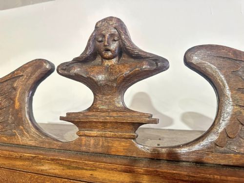 fig 10. A Victorian carved oak bureau bookcase featuring a scrolled pediment top, two carved upper doors, a slope-front writing surface with relief carvings, and four lower drawers with brass handles.