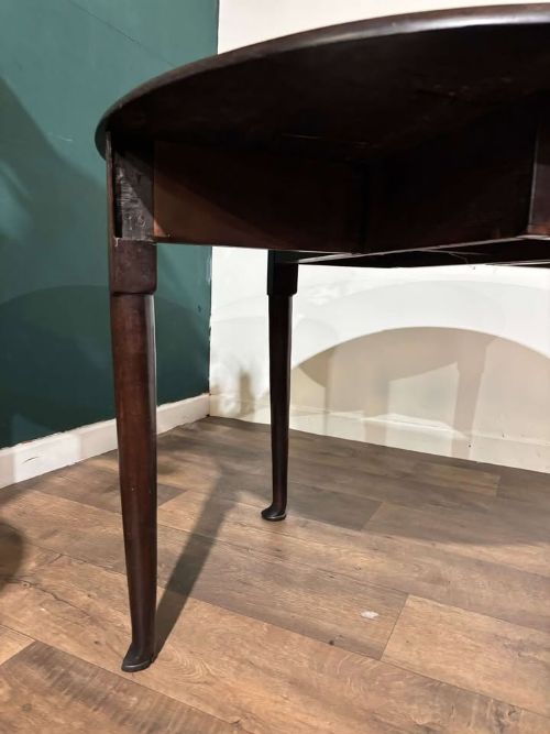 fig 5. An antique dark walnut drop leaf table with slender turned legs and side leaves folded down.