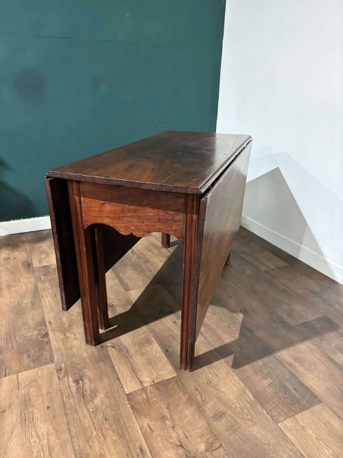 fig 2. A Georgian mahogany drop leaf table with two extended hinged flaps and reeded square legs.