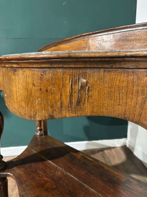 fig 1. A Victorian mahogany console table featuring a serpentine-contoured top, low splashback, turned and fluted legs, and a matching lower tier shelf.