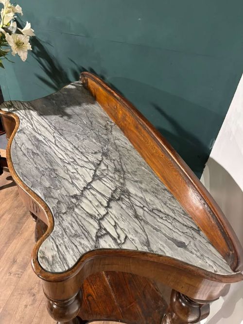 fig 2. A Victorian mahogany console table featuring a serpentine-contoured top, low splashback, turned and fluted legs, and a matching lower tier shelf.